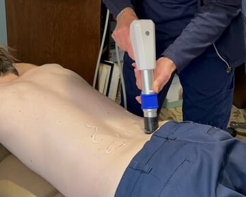 Person with chronic back pain seeking wave therapy in Marysville, Ohio