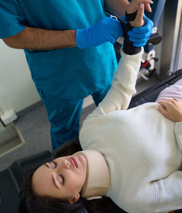 Sick patient is next to the doctor while he puts on an orthopedic fixator in the area of the left hand